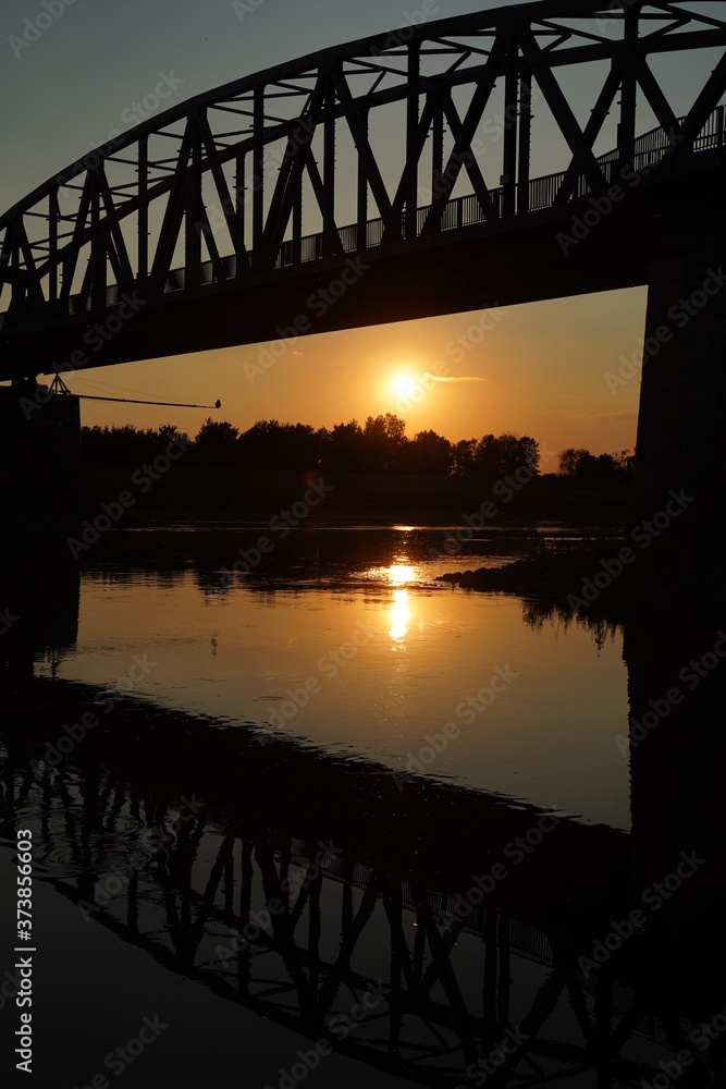 Obraz premium The reflection of the old bridge on the river,The silhouette of the old bridge at sunrise or sunset in the countryside