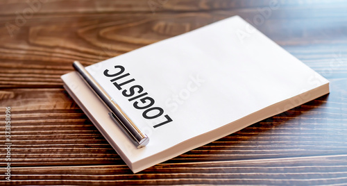 Close-up of silver pen on LOGISTIC on wooden background