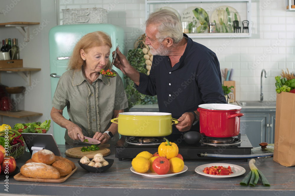 Happy senior couples cook an organic homemade meal in a family kitchen together with smile