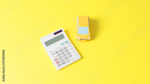 A photo-realistic CG illustration of a car toy and a calculator on a plane.