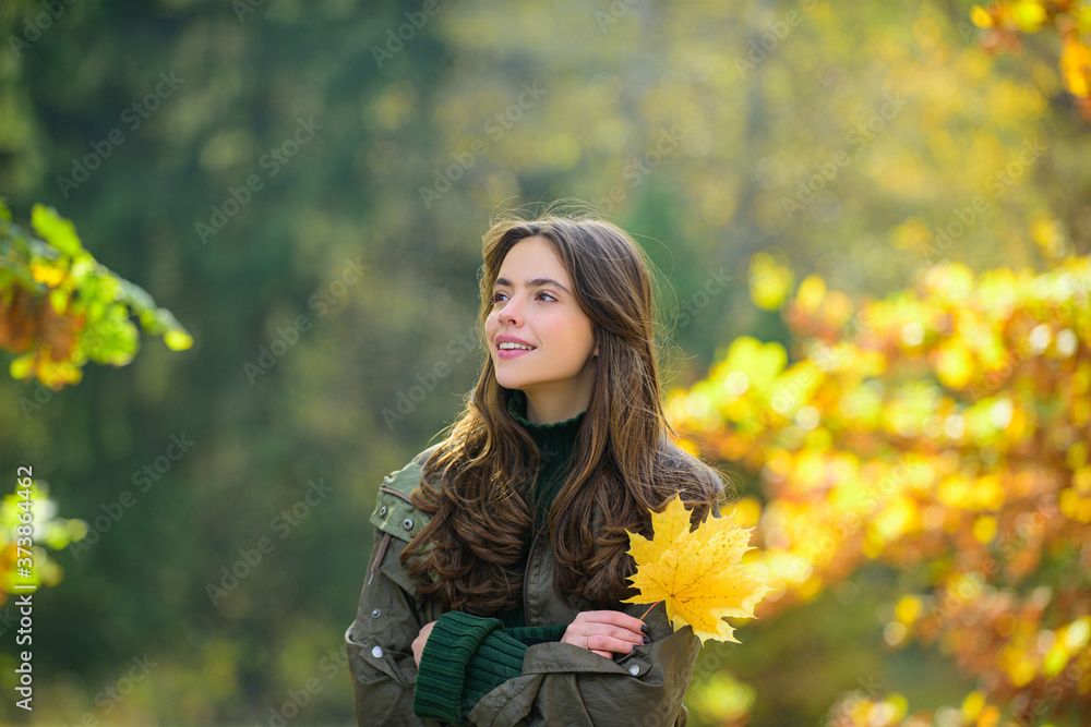 Beautiful girl in stylish fashion clothes in autumn Park. Beautiful woman outdoors in sunny day.