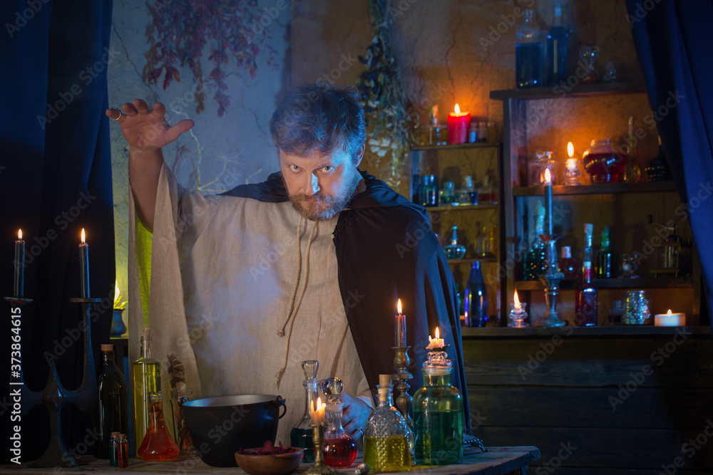 portrait of  wizard with burning candles and magic potions