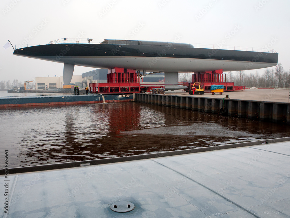 Transport of a super sailing yacht on a pontoon on the river. Keteldiep. Netherlands. Tugboat. Transport of a super sailing yacht on a pontoon on the river. Keteldiep. Netherlands. Tugboat.