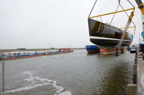 Launching of a super super sailing yacht in the harbor of Harlingen. Friesland. Netherlands. Shipbuilding industry. Cranes