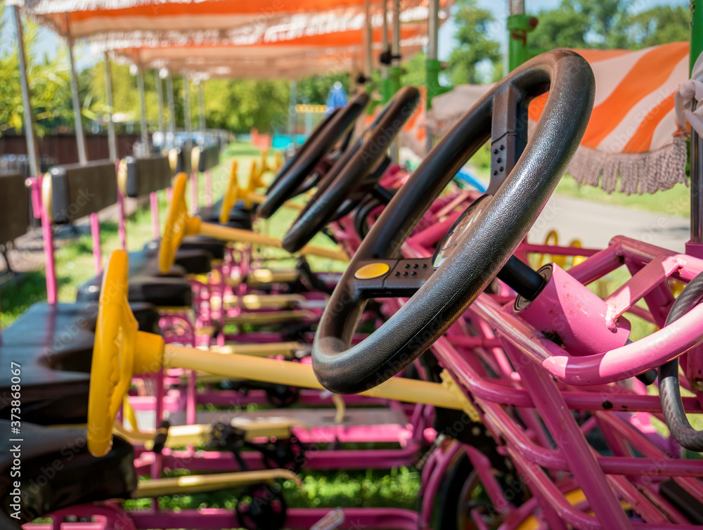 Close up with the wheel of a go cart. Tourist carts with pedals aligned.