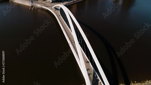 Aerial view overlooking people on a white bridge, sunny day, in the Kalasatama area, Helsinki city, Uusimaa, Finland - Static, drone shot photo