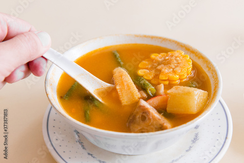 10 July 2017, Jakarta, Indonesia: Man Scoop Indonesia Sayur Asem or Sweet Sour Soup.