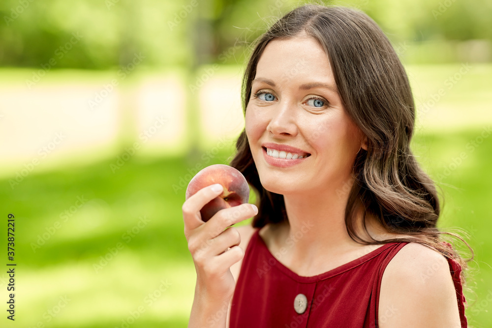 healthy eating and people concept - portrait of happy woman with peach at summer park healthy eating and people concept - portrait of happy woman with peach at summer park