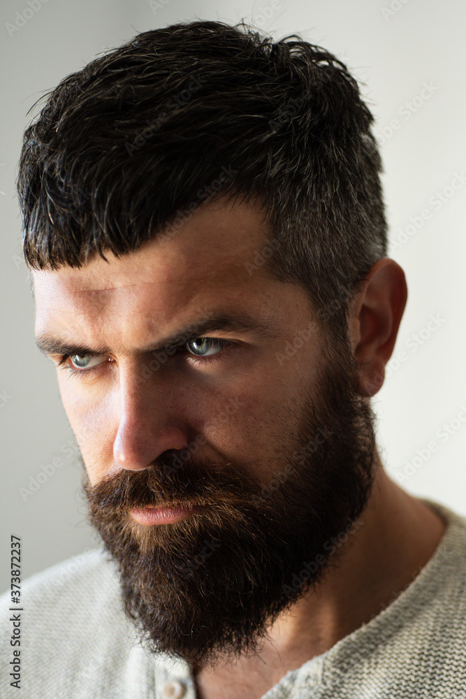 Obraz premium Portrait of confident serious man has beard and mustache. Handsome male model, closeup face. Bearded hipster with moustache in barbershop.