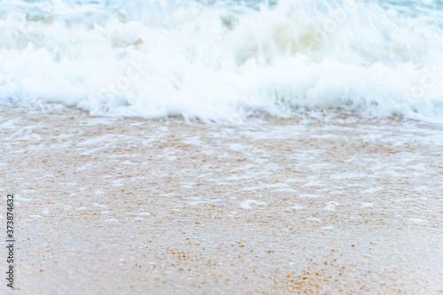 Close up ocean wave bubble on sandy beach. Background for vacation holiday and natural feeling.