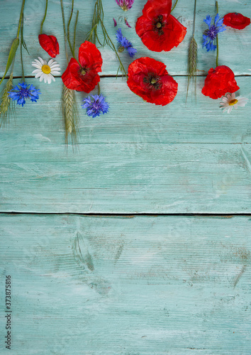 cornflowers on turquoise surface on wooden surface photo