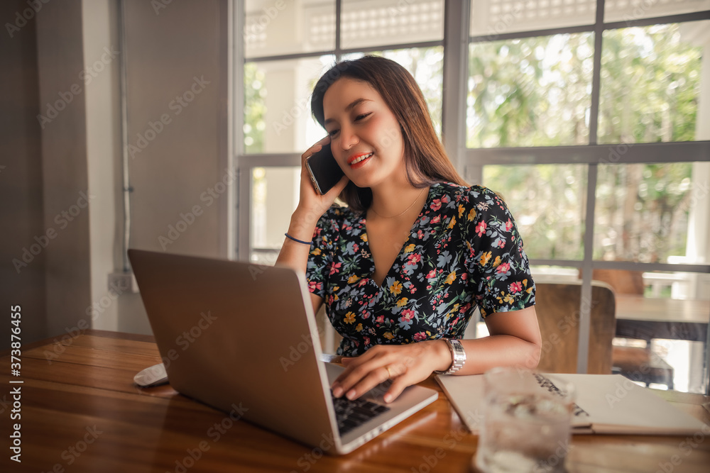 Young lifestyle beautiful Asian woman working from home using smartphone and notebook computer, Attraction business woman online call mobile phone, Asia business people check something new on laptop Young lifestyle beautiful Asian woman working from home using smartphone and notebook computer, Attraction business woman online call mobile phone, Asia business people check something new on laptop