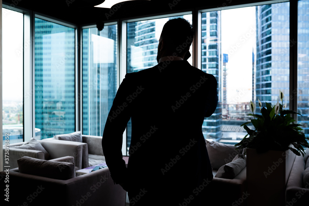 Respectable businessman making phone call in contemporary office Respectable businessman making phone call in contemporary office