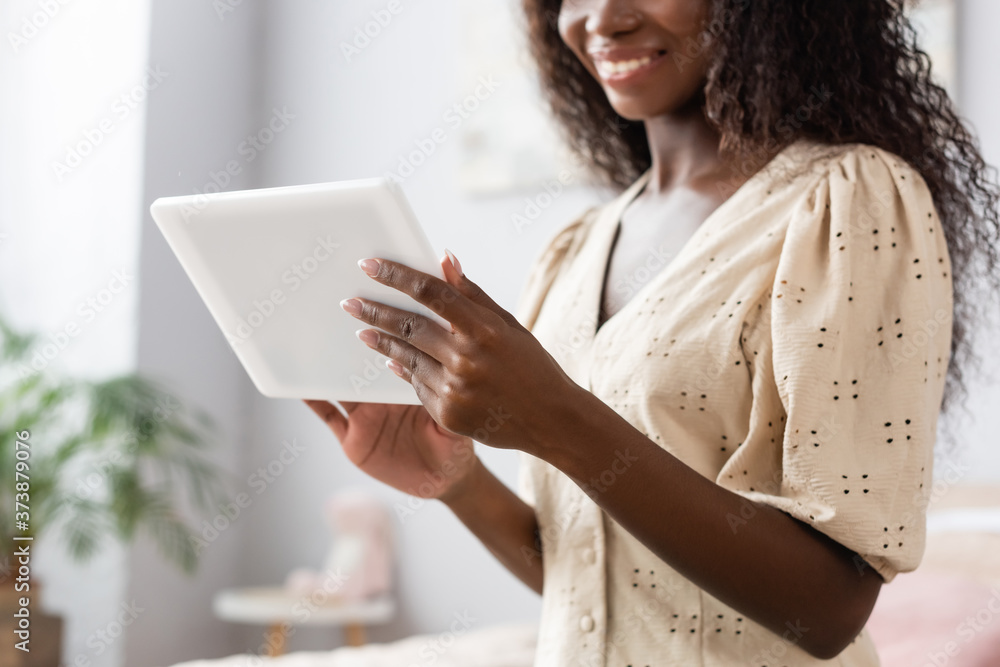 cropped view of african american woman in blouse using digital tablet at home cropped view of african american woman in blouse using digital tablet at home