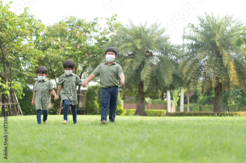 3 brothers are walking and playing in the garden in the evening.. © No-Te