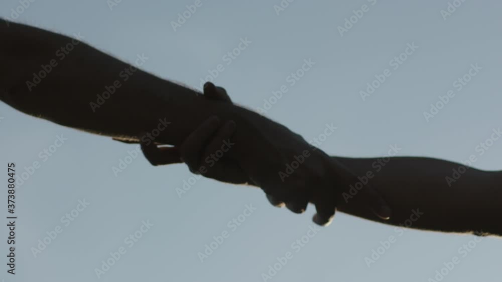 hands are held tightly to help each other up