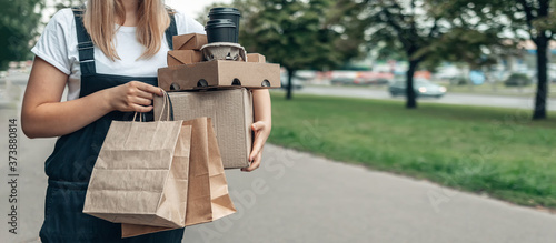 Contactless delivery. Girl Courier with food takeaway zero waste paper packaging delivers groceries. Concept takeaway take-out  carry-out  stay home