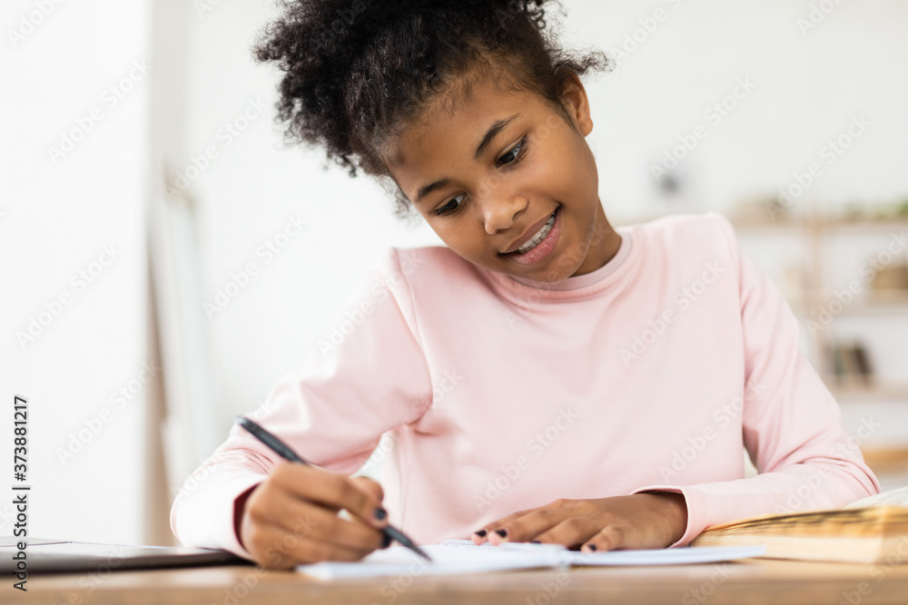 African Teen Girl Doing Homework Writing In Exercise-Book At Home African Teen Girl Doing Homework Writing In Exercise-Book At Home