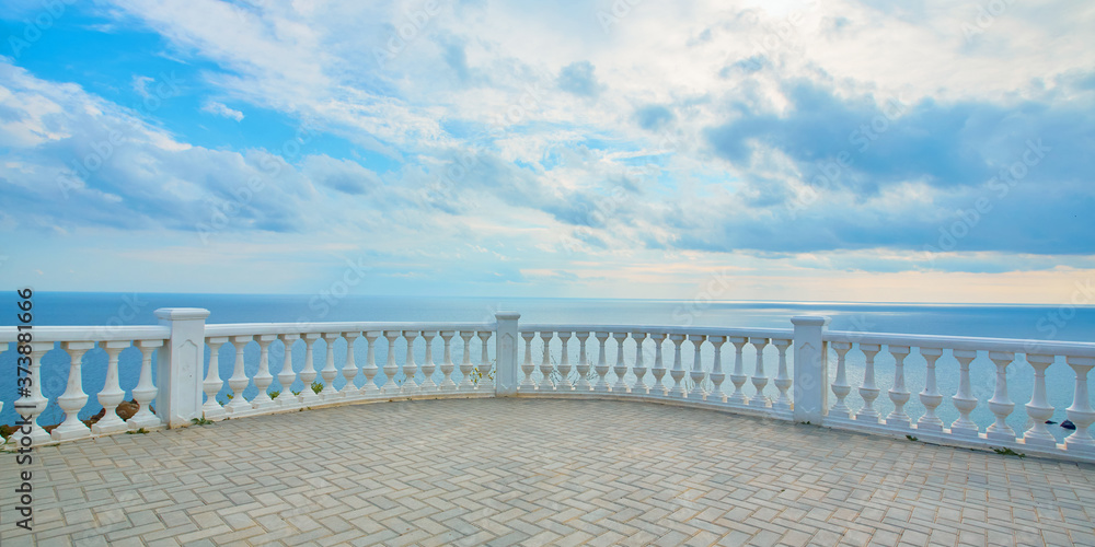 Summer time. Panoramic ocean view. Seascape. Empty promenade. Blue cloudy sky. Crystal calming sea water on horizon