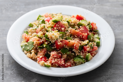 fresh vegetable salad with couscous on white plate
