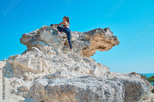 Rock climbing. Sport. Active lifestyle. Woman climb up on mountain. Strong and fit athlete. Nature workout. Blue sky