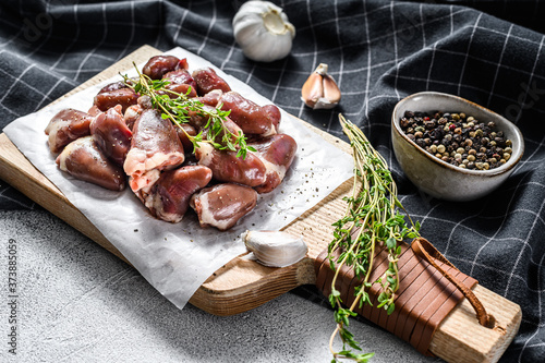 Raw chicken hearts on a cutting board. Organic offal. White background. Top view