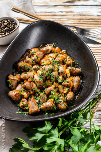 Stew with chicken hearts and vegetables with fresh parsley. White background. Top view