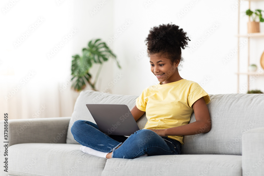 African Teen Girl Using Laptop Browsing Internet Sitting At Home African Teen Girl Using Laptop Browsing Internet Sitting At Home