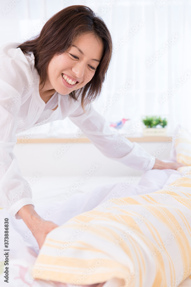 布団を整える女性 布団を整える女性