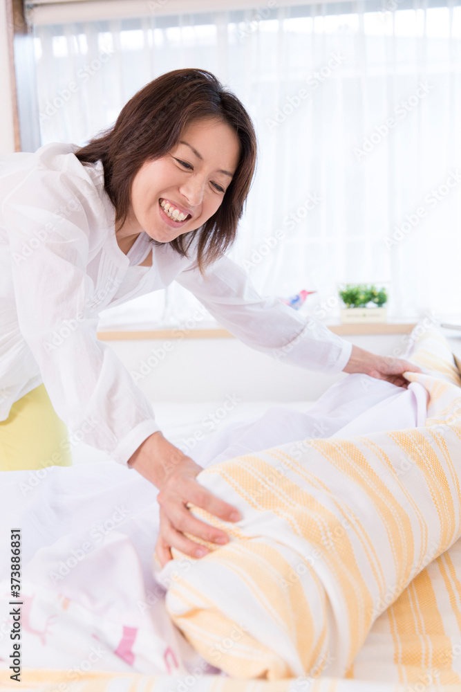 布団を整える女性 布団を整える女性