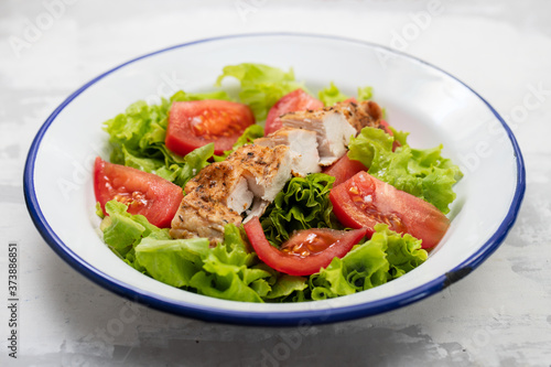 fresh salad with grilled chicken and sauce on the plate