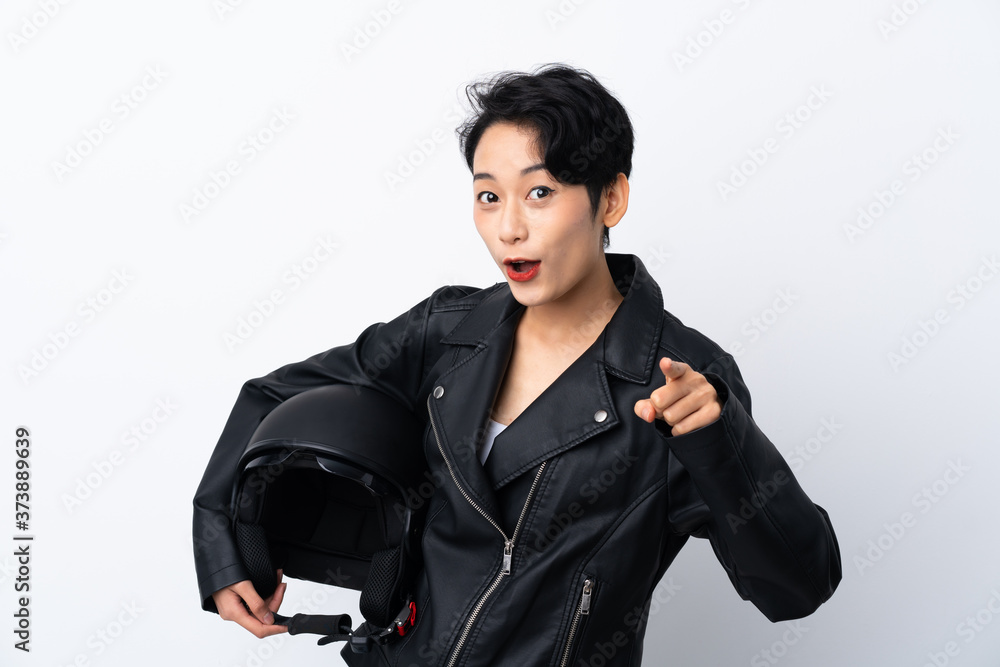 Young Asian girl with a motorcycle helmet over isolated white background surprised and pointing front Young Asian girl with a motorcycle helmet over isolated white background surprised and pointing front