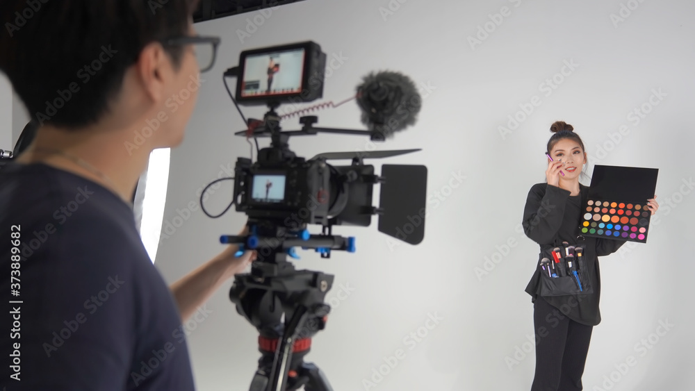 撮影スタジオでセミナーの動画を撮るカメラマンとヘアメイクアーティスト