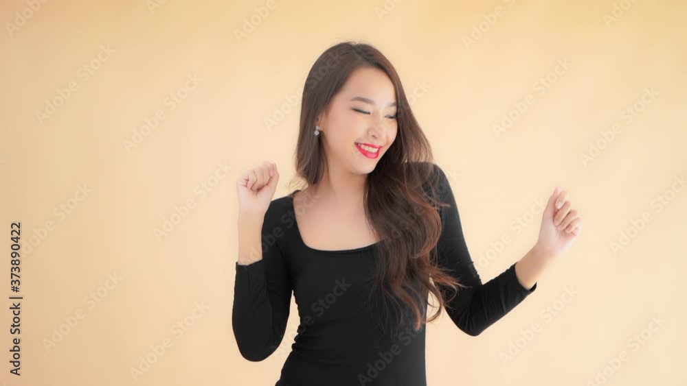 A gorgeous young woman in a little back dress raises her arms laughs and dances. A gorgeous young woman in a little back dress raises her arms laughs and dances.
