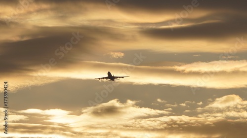 an airplane flying through the clouds at sunrise 