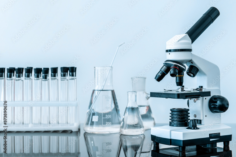 Microscope and glassware on table in laboratory Microscope and glassware on table in laboratory