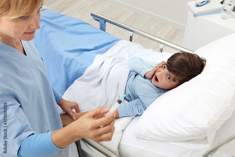 Obraz premium Up view of nurse checking syringe after giving an injection to sick child lying in bed in hospital room