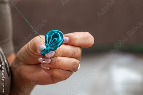 old female hands sew fabric with a needle and thread
