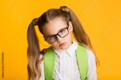 Overworked Schoolgirl Looking At Camera Posing Over Yellow Background