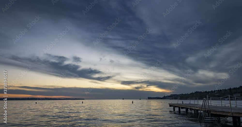 Time lapse of dramatic and colorful sunset over concrete pier and small town Portoroz in Slovenia. Adriatic Sea in summer. People taking photos. Wide static shot Time lapse of dramatic and colorful sunset over concrete pier and small town Portoroz in Slovenia. Adriatic Sea in summer. People taking photos. Wide static shot