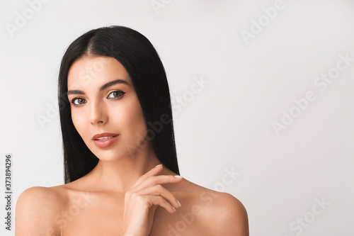 Young woman with beautiful eyeshadows on light background