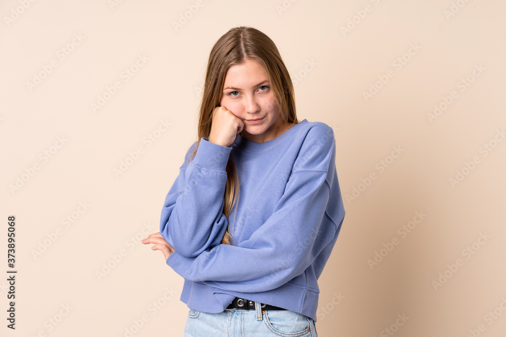 Teenager Ukrainian girl isolated on beige background with tired and bored expression Teenager Ukrainian girl isolated on beige background with tired and bored expression