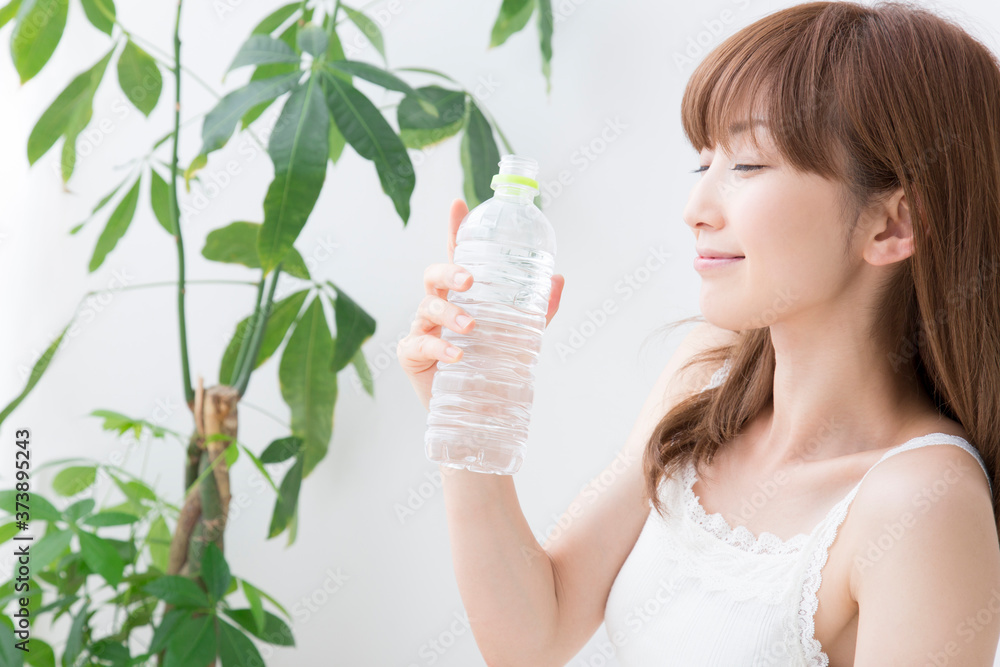 ペットボトルの水を飲む女性