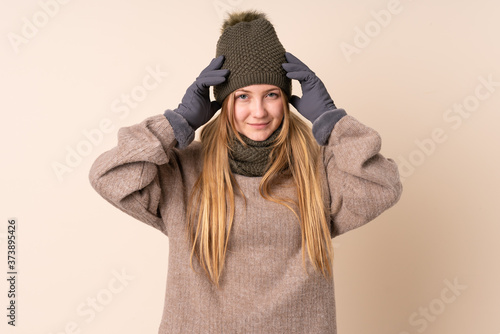 Teenager Ukrainian girl with winter hat isolated on beige background unhappy and frustrated with something. Negative facial expression © luismolinero