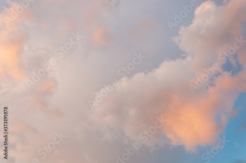 Golden clouds in a blue sky lit by the sun