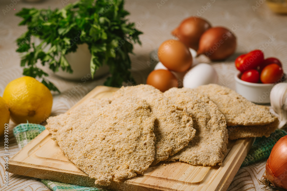 Milanesas Crudas en Tabla de madera Milanesas Crudas en Tabla de madera