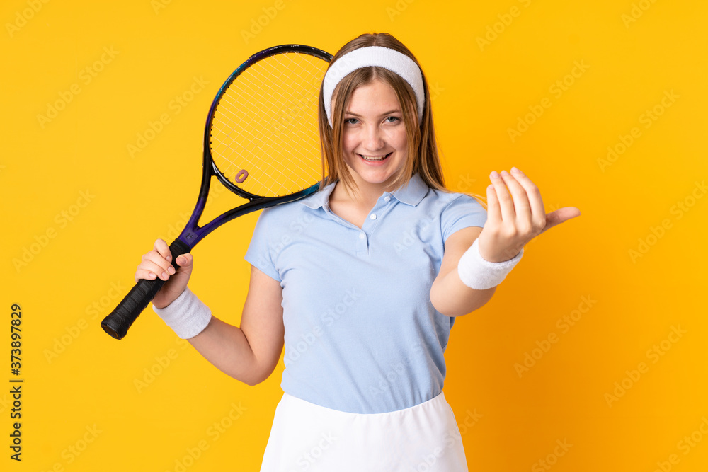 Teenager Ukrainian girl tennis player isolated on yellow background playing tennis and doing coming gesture Teenager Ukrainian girl tennis player isolated on yellow background playing tennis and doing coming gesture