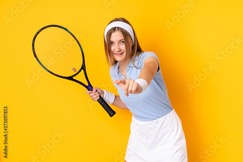 Teenager Ukrainian girl tennis player isolated on yellow background playing tennis