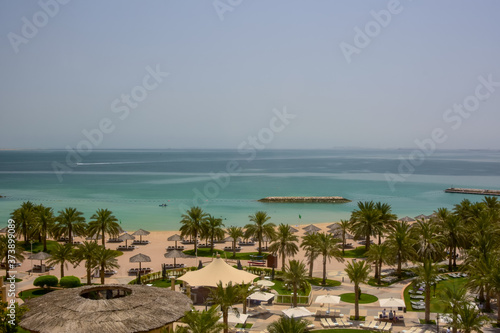 elevated viewpoint of palm trees and beach to the beautiful blue waters of the Persian Gulf © NextStopWorldPhoto