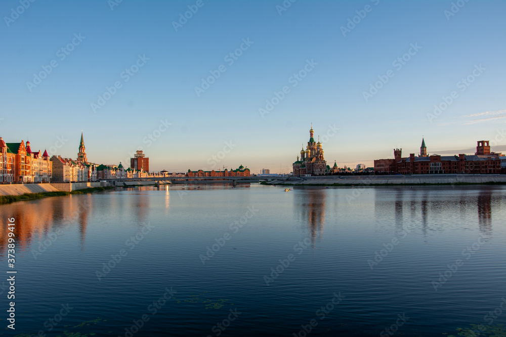 Russia, Yoshkar-Ola, July 24, 2020, view from the bridge at sunset, the Kremlin and the Kokshaga river, reflection in the water.